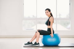 Jeune exercice asiatique sexy de fille, sourire sur la boule de forme physique au gymnase à la maison propre, club de sports Clas photos stock Jeune exercice asiatique sexy de fille, sourire sur la boule de forme physique au gymnase à la maison propre, club de sports Clas photos stock