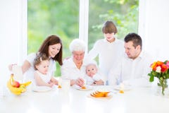 Jeune famille heureuse appréciant le petit déjeuner de Pâques photo libre de droits Jeune famille heureuse appréciant le petit déjeuner de Pâques photo libre de droits