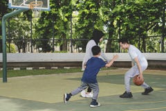 Jeune famille musulmane jouant au basket-ball dans le domaine image stock Jeune famille musulmane jouant au basket-ball dans le domaine image stock