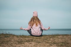 Jeune femme adulte dans le chapeau rose seul se reposant sur les bluffs, regard de la mer, concept de libert?, l'atmosph?re paisi photos libres de droits Jeune femme adulte dans le chapeau rose seul se reposant sur les bluffs, regard de la mer, concept de libert?, l'atmosph?re paisi photos libres de droits