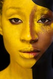 Jeune femme africaine gaie avec le maquillage de mode d'art Une femme étonnante avec le maquillage noir et jaune de peinture image libre de droits Jeune femme africaine gaie avec le maquillage de mode d'art Une femme étonnante avec le maquillage noir et jaune de peinture image libre de droits