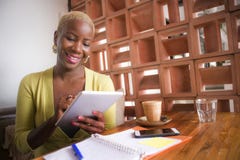 Jeune femme américaine d'affaires d'africain noir élégant et bel travaillant en ligne avec la protection numérique de comprimé au photos libres de droits Jeune femme américaine d'affaires d'africain noir élégant et bel travaillant en ligne avec la protection numérique de comprimé au photos libres de droits