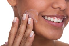 Jeune femme appliquant la crème sur son visage photographie stock Jeune femme appliquant la crème sur son visage photographie stock
