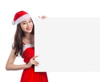 Jeune femme asiatique de Noël montrant le signe vide de bannière de panneau d'affichage photo libre de droits Jeune femme asiatique de Noël montrant le signe vide de bannière de panneau d'affichage photo libre de droits