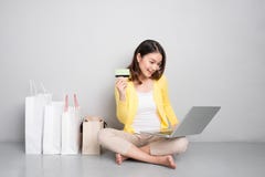 Jeune femme asiatique faisant des emplettes en ligne à la maison se reposant sans compter que la rangée de photo stock Jeune femme asiatique faisant des emplettes en ligne à la maison se reposant sans compter que la rangée de photo stock