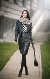 Jeune femme attirante dans un tir de mode d'hiver. Belle jeune fille à la mode en cuir noir se réveillant sur l'avenue. Femme élég Photos libres de droits Jeune femme attirante dans un tir de mode d'hiver. Belle jeune fille à la mode en cuir noir se réveillant sur l'avenue. Femme élég Photos libres de droits