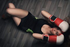 Jeune femme avec de longs cheveux blonds et yeux fermés, habillés dans l'habillement de forme physique et les gants de boxe rouge images libres de droits Jeune femme avec de longs cheveux blonds et yeux fermés, habillés dans l'habillement de forme physique et les gants de boxe rouge images libres de droits