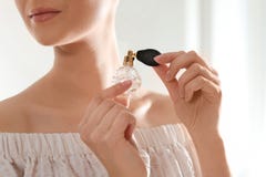 Jeune femme avec la bouteille de parfum sur le fond brouillé image libre de droits Jeune femme avec la bouteille de parfum sur le fond brouillé image libre de droits