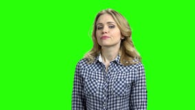 Jeune femme avec le regard méfiant sur l'écran vert Jeune femme avec le regard méfiant sur l'écran vert