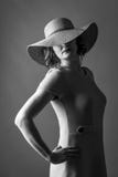 Jeune femme avec une robe intéressante de chapeau et des lèvres rouges image stock Jeune femme avec une robe intéressante de chapeau et des lèvres rouges image stock