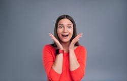 Jeune femme comblée réagissant à une surprise agréable image stock Jeune femme comblée réagissant à une surprise agréable image stock