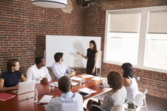 Jeune femme d'affaires Addressing Boardroom Meeting photos libres de droits Jeune femme d'affaires Addressing Boardroom Meeting photos libres de droits