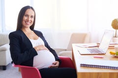 Jeune femme d'affaires enceinte travaillant au bureau photo libre de droits Jeune femme d'affaires enceinte travaillant au bureau photo libre de droits