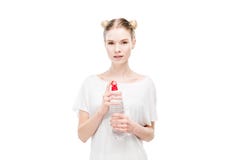 Jeune femme dans le T-shirt blanc tenant la bouteille avec de l'eau et regardant l'appareil-photo photographie stock libre de droits Jeune femme dans le T-shirt blanc tenant la bouteille avec de l'eau et regardant l'appareil-photo photographie stock libre de droits