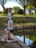 Jeune femme dans un imperméable, collants, chaussures avec des talons, avec un sac en cuir noir dans des ses mains photos libres de droits Jeune femme dans un imperméable, collants, chaussures avec des talons, avec un sac en cuir noir dans des ses mains photos libres de droits
