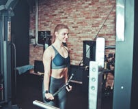 Jeune femme de forme physique dans l'usage de sport avec le corps musculaire photographie stock Jeune femme de forme physique dans l'usage de sport avec le corps musculaire photographie stock