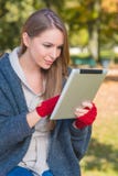 Jeune femme de sourire occupée avec Apple Ipad Images stock Jeune femme de sourire occupée avec Apple Ipad Images stock