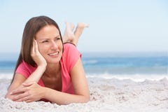 Jeune femme détendant sur la plage sablonneuse photos stock Jeune femme détendant sur la plage sablonneuse photos stock