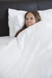 Jeune femme enceinte réfléchie se situant dans le lit photographie stock libre de droits Jeune femme enceinte réfléchie se situant dans le lit photographie stock libre de droits