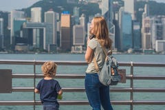 Jeune femme et son fils prenant des photos de port de Victoria en Hong Kong, Chine photographie stock libre de droits Jeune femme et son fils prenant des photos de port de Victoria en Hong Kong, Chine photographie stock libre de droits