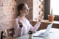 Jeune femme faisant la méditation dans le bureau au travail images libres de droits Jeune femme faisant la méditation dans le bureau au travail images libres de droits