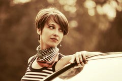 Jeune femme heureuse de mode dans le dessus de réservoir à côté de sa voiture photos libres de droits Jeune femme heureuse de mode dans le dessus de réservoir à côté de sa voiture photos libres de droits