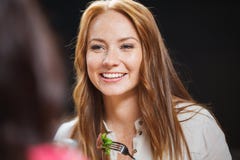 Jeune femme heureuse dînant au restaurant images libres de droits Jeune femme heureuse dînant au restaurant images libres de droits