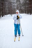 Jeune femme heureuse et souriante seul skiant dans la forêt d'hiver photographie stock Jeune femme heureuse et souriante seul skiant dans la forêt d'hiver photographie stock