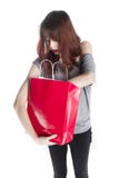 Jeune femme regardant dans le panier rouge photographie stock libre de droits Jeune femme regardant dans le panier rouge photographie stock libre de droits