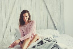Jeune femme sexy dans la lingerie rose détendant à la maison dans le lit images stock Jeune femme sexy dans la lingerie rose détendant à la maison dans le lit images stock