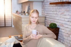 Jeune femme tenant la tasse de thé à la maison image libre de droits Jeune femme tenant la tasse de thé à la maison image libre de droits