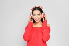 Jeune femme écoutant la musique de Noël photos stock Jeune femme écoutant la musique de Noël photos stock