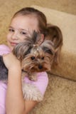 Jeune fille blonde mignonne avec son chiot de terrier de Yorkshire se trouvant sur le sofa image libre de droits Jeune fille blonde mignonne avec son chiot de terrier de Yorkshire se trouvant sur le sofa image libre de droits