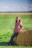 Jeune fille de l'adolescence mignonne posant près d'une meule de foin dans le domaine photo libre de droits Jeune fille de l'adolescence mignonne posant près d'une meule de foin dans le domaine photo libre de droits