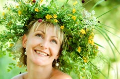 Jeune fille heureuse en guirlande des herbes et des fleurs Jour d'été dans un pré photographie stock Jeune fille heureuse en guirlande des herbes et des fleurs Jour d'été dans un pré photographie stock