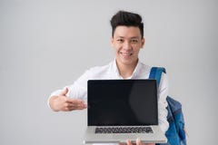 Jeune homme asiatique dans des vêtements sport tenant et montrant l'écran de photos stock Jeune homme asiatique dans des vêtements sport tenant et montrant l'écran de photos stock