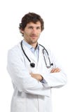 Jeune homme attirant de docteur posant avec les bras pliés Photos libres de droits Jeune homme attirant de docteur posant avec les bras pliés Photos libres de droits