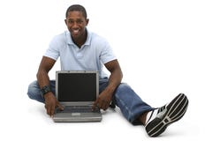 Jeune homme attirant s'asseyant sur l'étage avec l'ordinateur portable photo libre de droits Jeune homme attirant s'asseyant sur l'étage avec l'ordinateur portable photo libre de droits