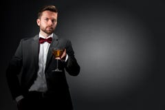 Jeune homme avec un verre de cocktail photographie stock libre de droits Jeune homme avec un verre de cocktail photographie stock libre de droits