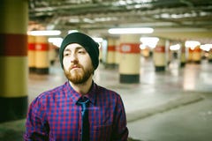 Jeune homme avec une barbe dans une chemise de plaid et un lien et un chapeau photos libres de droits Jeune homme avec une barbe dans une chemise de plaid et un lien et un chapeau photos libres de droits