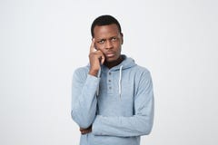 Jeune homme beau d'afro-américain recherchant avec l'expression réfléchie et sceptique image libre de droits Jeune homme beau d'afro-américain recherchant avec l'expression réfléchie et sceptique image libre de droits
