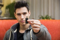 Jeune homme beau montrant la clé d'USB dans sa main photo libre de droits Jeune homme beau montrant la clé d'USB dans sa main photo libre de droits