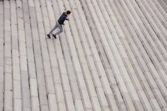 Jeune homme courant en haut dans la ville moderne image libre de droits Jeune homme courant en haut dans la ville moderne image libre de droits