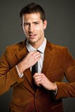 Jeune homme d'affaires mettant le sien relation étroite Photos libres de droits Jeune homme d'affaires mettant le sien relation étroite Photos libres de droits