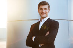 Jeune homme d'affaires réussi sûr se tenant avec des bras croisés images stock Jeune homme d'affaires réussi sûr se tenant avec des bras croisés images stock