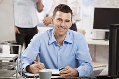 Jeune homme d'affaires travaillant dans le bureau image stock Jeune homme d'affaires travaillant dans le bureau image stock