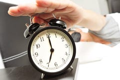 Jeune homme dans le lit avec un masque de sommeil arrêtant le réveil image stock Jeune homme dans le lit avec un masque de sommeil arrêtant le réveil image stock