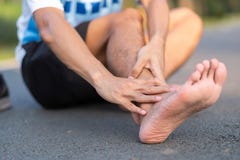 Jeune homme de forme physique tenant sa blessure à la jambe de sports muscle douloureux pendant la formation Coureur asiatique ay photo stock Jeune homme de forme physique tenant sa blessure à la jambe de sports muscle douloureux pendant la formation Coureur asiatique ay photo stock