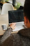 Jeune homme détendu de programmeur professionnel surfant l'Internet sur son ordinateur portable dans un café, smartphone sur la t photographie stock libre de droits Jeune homme détendu de programmeur professionnel surfant l'Internet sur son ordinateur portable dans un café, smartphone sur la t photographie stock libre de droits