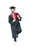 Jeune homme enthousiaste dans le chapeau d'obtention du diplôme tenant le diplôme et triomphant Images libres de droits Jeune homme enthousiaste dans le chapeau d'obtention du diplôme tenant le diplôme et triomphant Images libres de droits